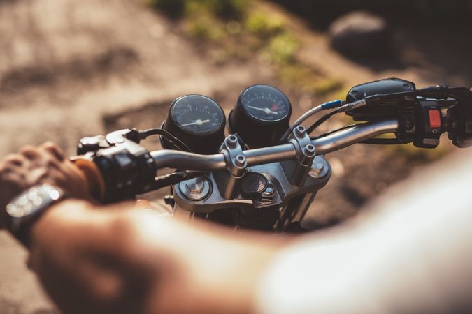 Cropped image of man riding motorcycle on road