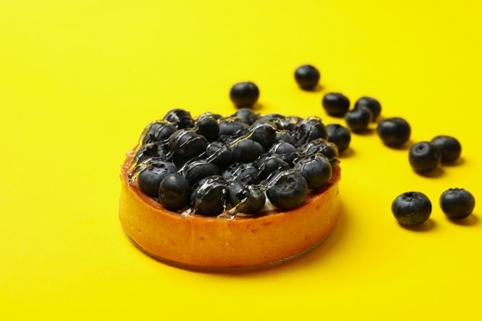 Blueberry pie on yellow background, close up