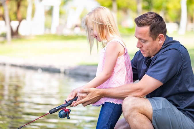 Young White Father and Daughter Having Fun Fishing At The Lake