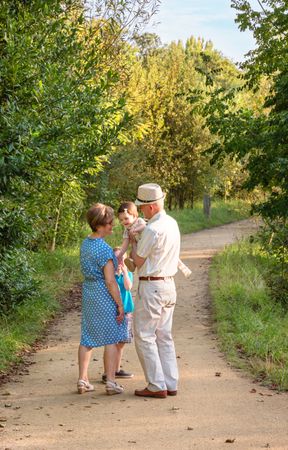 Grandparents and grandchildren walking outdoors among trees