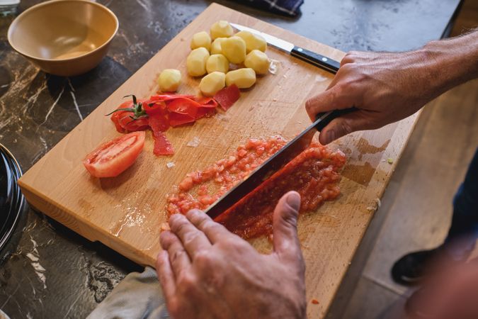 Man chopping tomato with knife
