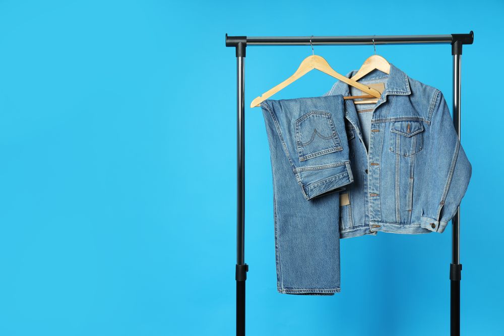Jeans hang on hangers on a blue background