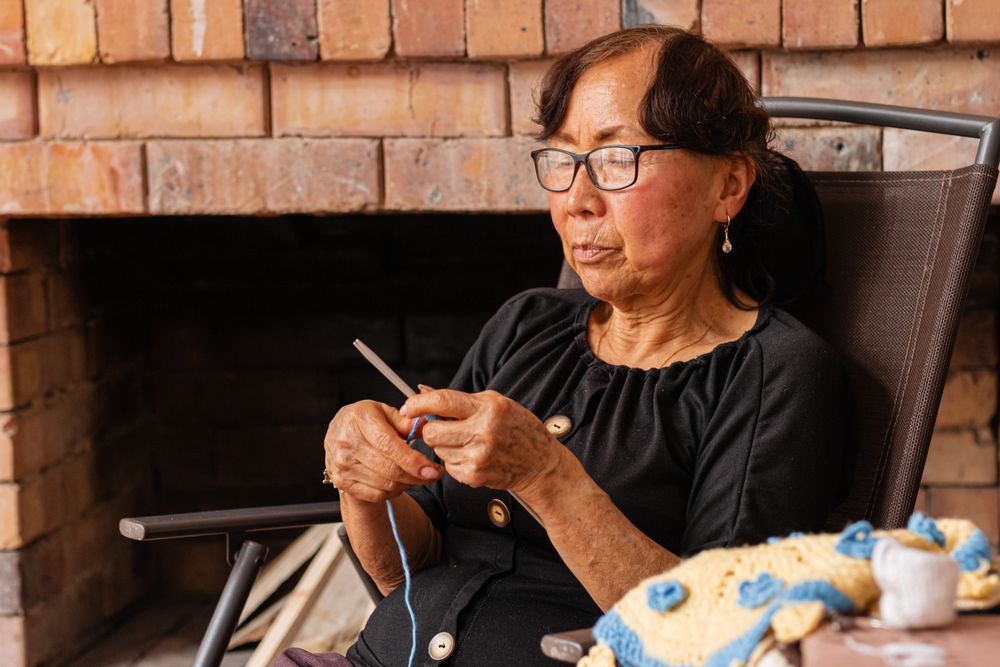Serenity in stitches. Latina woman knits at home.