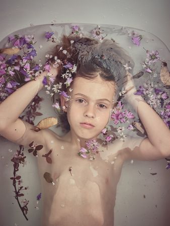 Boy in bathtub with colorful flowers