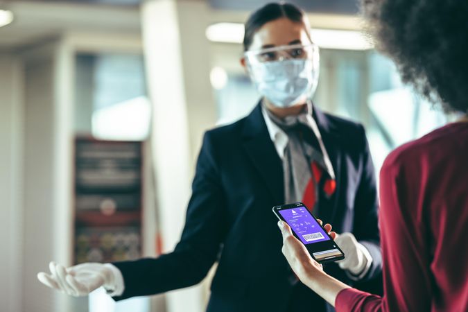Woman checking in using digital boarding pass at airport terminal during pandemic