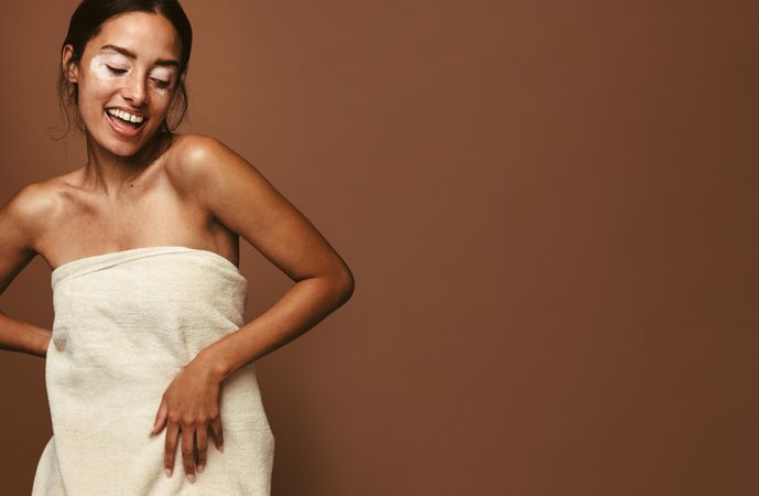 Woman with vitiligo disease having fun in bath towel