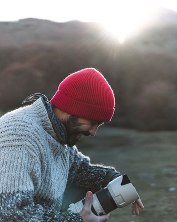 Photographer holding camera from backpack