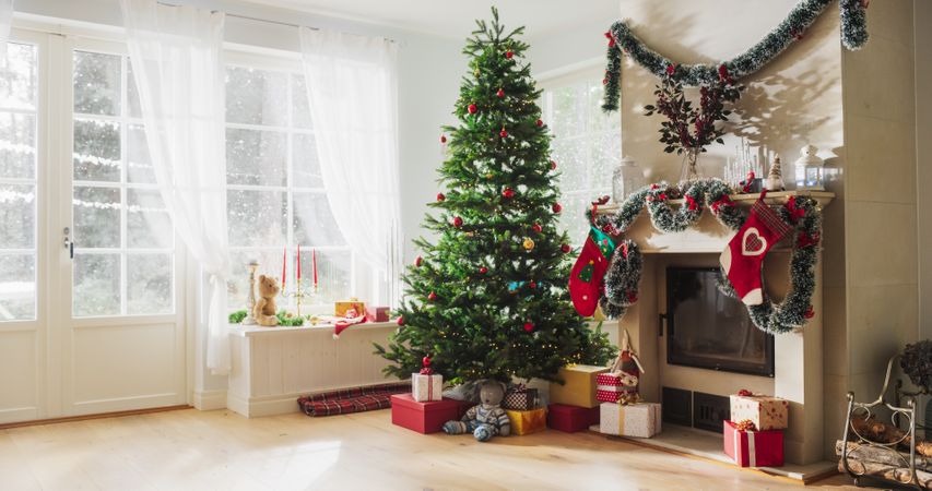 Close Up on Decorated Fireplace with Stockings Next to a Christmas Tree.
