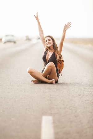 Smiling woman sitting on road