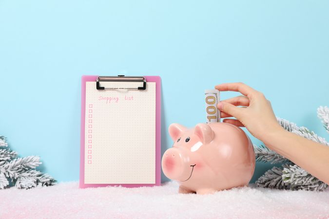 Folder with paper with list, piggy bank and hand with cash on blue background