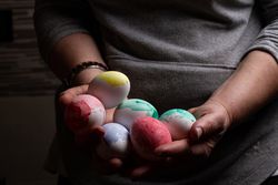 Woman holding many Easter eggs in darkness