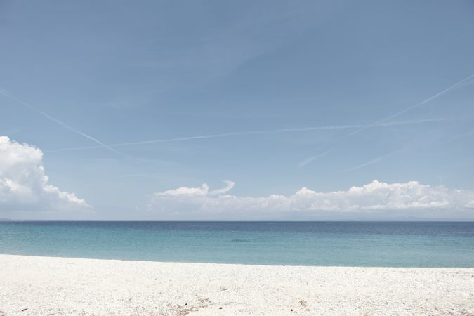 Seascape of white sandy shore and calm water