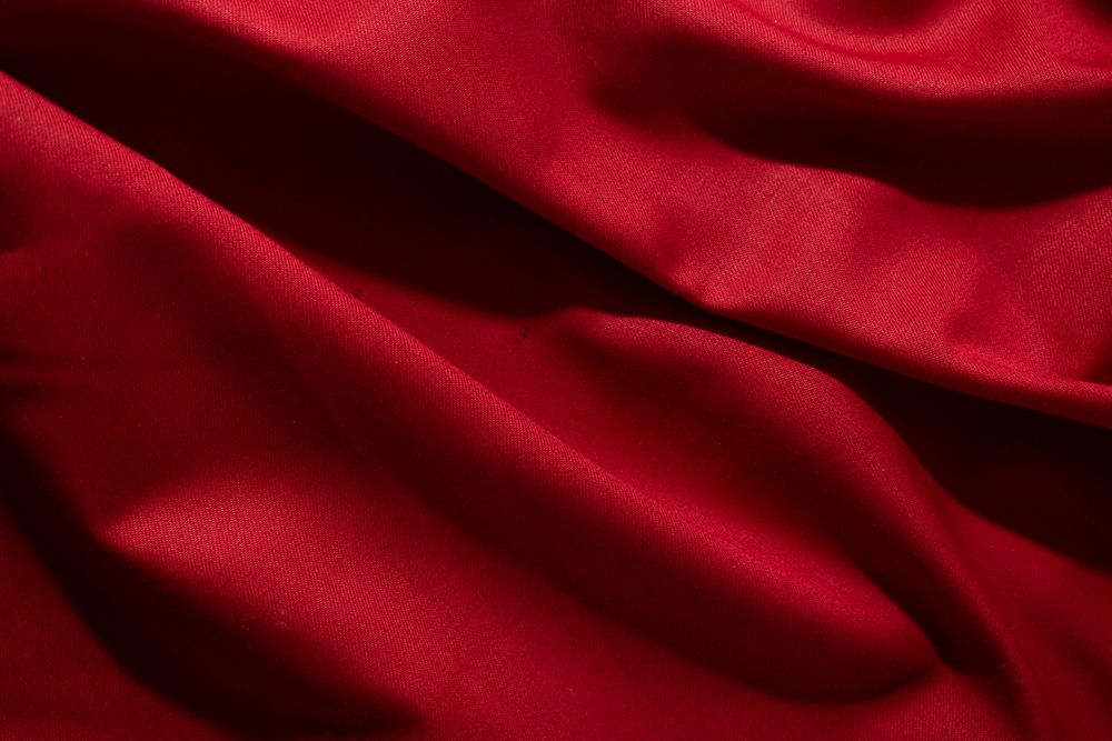 Close Up Crumpled wavy Red silky fabric background texture.