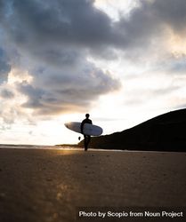 Silhouette of man holding surfboard at the beach 5zPWXb