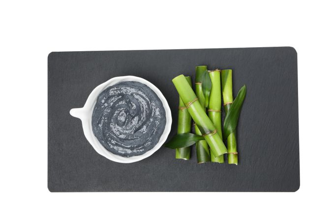 Fresh bamboo shoots with charcoal in the form of a paste, isolated on plain background