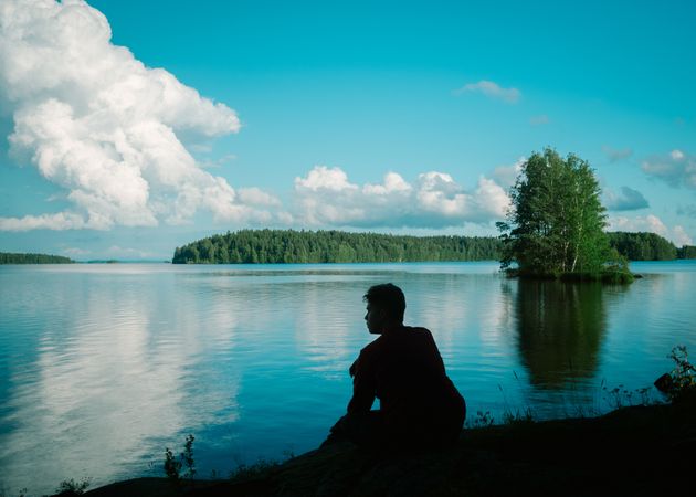 Young man sitting on riverside