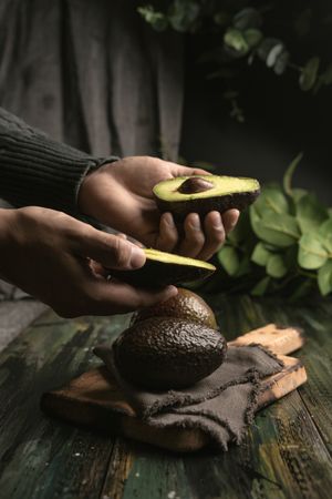Person hands holding avocados