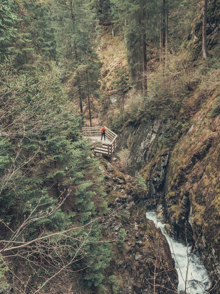 Traveller admiring picturesque view of mountain stream