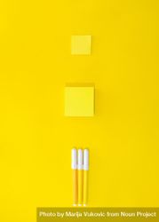 Three pens and post it notes on yellow background 0yLEab