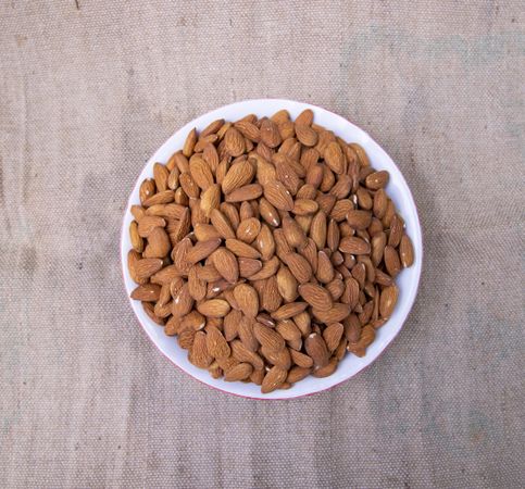 Top view of A Bowl almonds on brown fabric