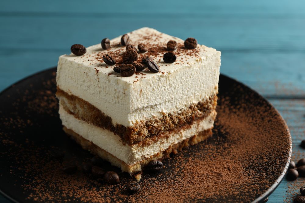 Plate with tiramisu on wooden background. Tasty dessert