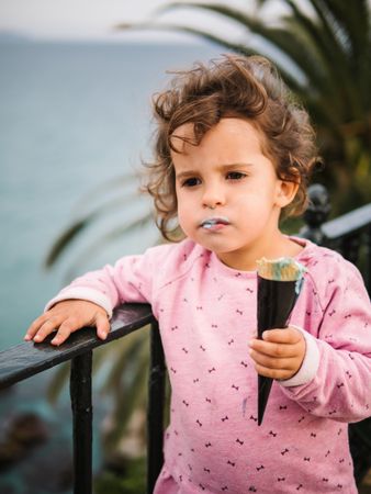 Adorable serious toddler girl with ice-cream