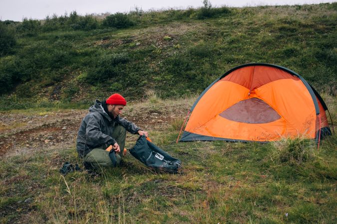 Man pitching tent in field