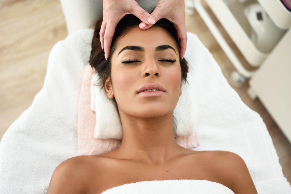 Woman receiving a facial treatment from a aesthetician