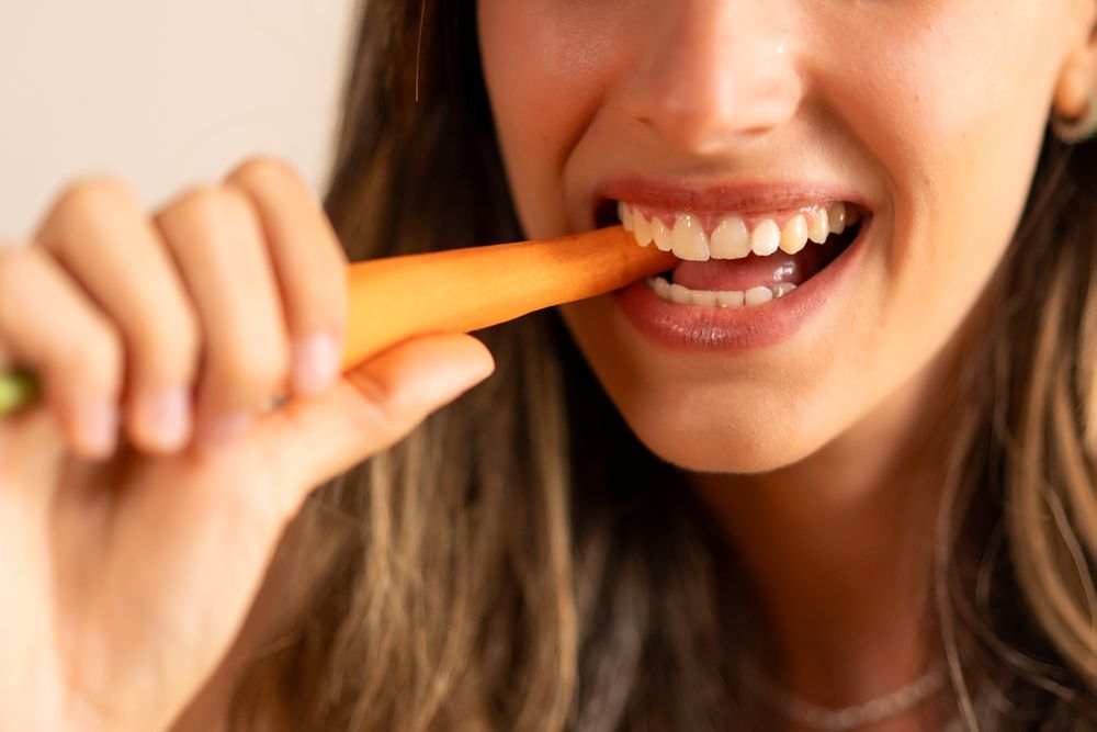 Close-Up of Woman Eating a Carrot - Healthy Snack Choice