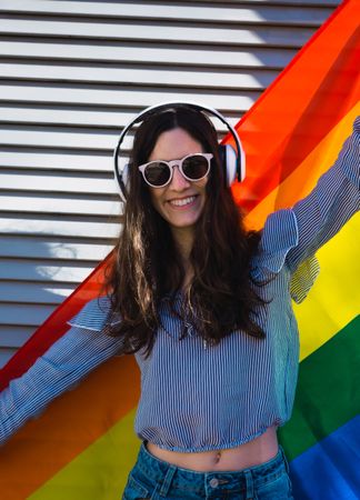 White woman posing happily with the LGBT flag