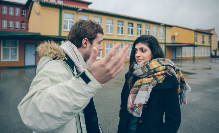 Couple standing outside having tense conversation