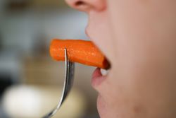 Woman Eating Carrot: Vitamin-Rich Nutritious Meal for Plant-Based Health.