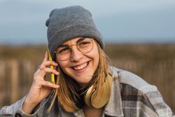 Smiling female talking on smartphone in nature