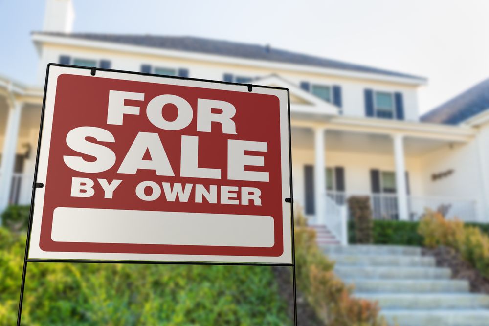 For Sale By Owner Real Estate Yard Sign In Front of House.
