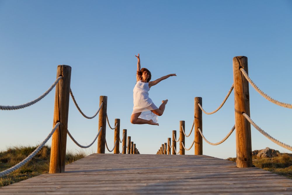 Woman posing in air on footbridge