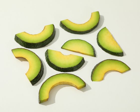 Fresh green avocado slices on blank background