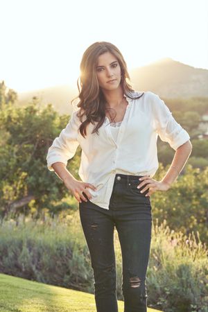 Self confident woman standing in field at sundown