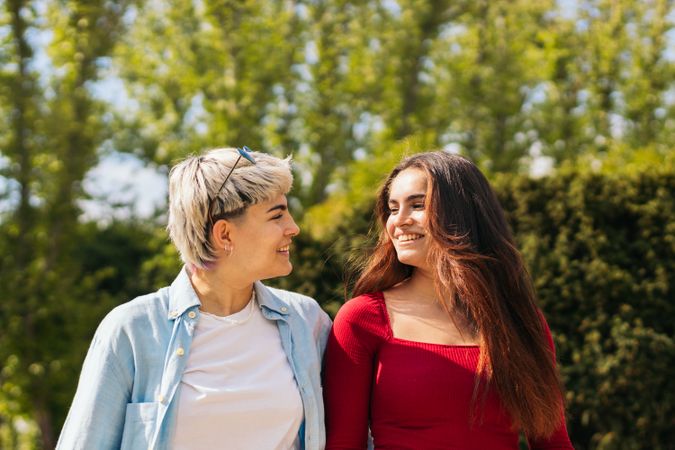 two women walking and looking each other in a park