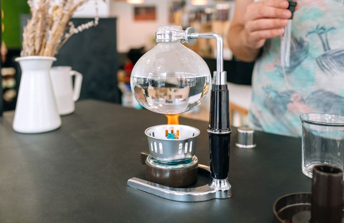 Japanese coffee maker boiling water while barista wait to put siphon and make a specialty coffee