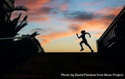 Silhouette of female runner working out against a sunset sky 4AzmmE