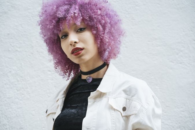 Stylish woman with pink hair looking at camera
