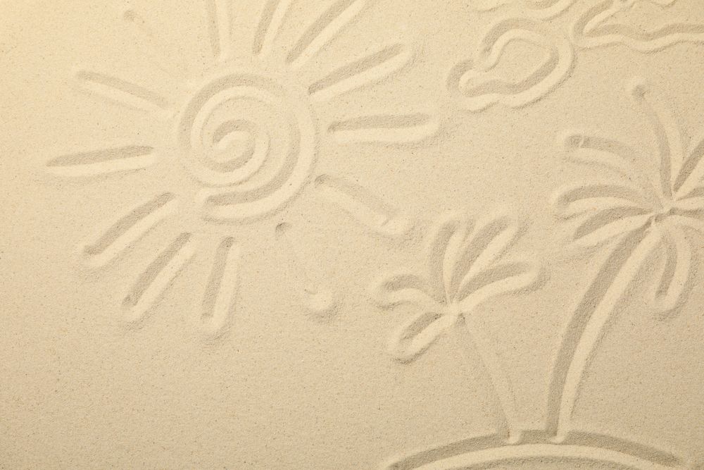 Sea sand with painted sun, clouds and palms on island