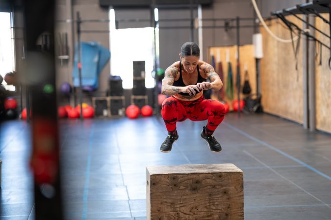 Strong woman exercising with a box in a gym