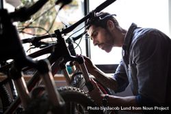 Man at a bicycle showroom making repairs 0VKwr5