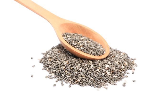 Chia seeds and wooden spoon isolated on blank background