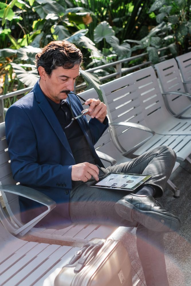 Mature handsome man using digital tablet outdoors