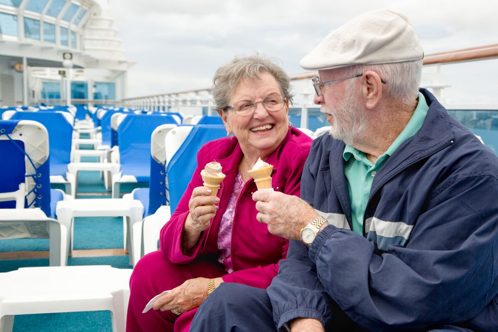 Happy Mature Adult Couple Enjoying Ice Cream On The Deck of a Luxury Passenger Cruise Ship.