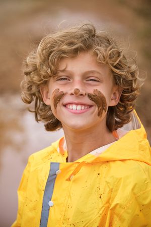 Smiling boy with mud on face