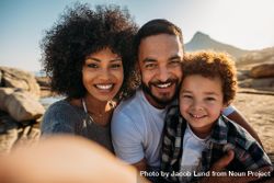 Close up shot of a smiling couple with a kid on a holiday. 5o1Eyb