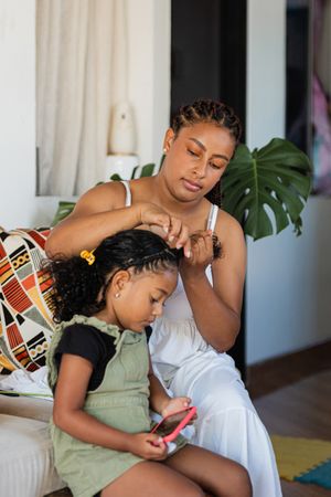 Mom combs her daughter's hair